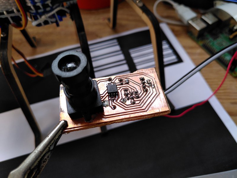The sensor printed circuit board with lens in place and test patterns in the background